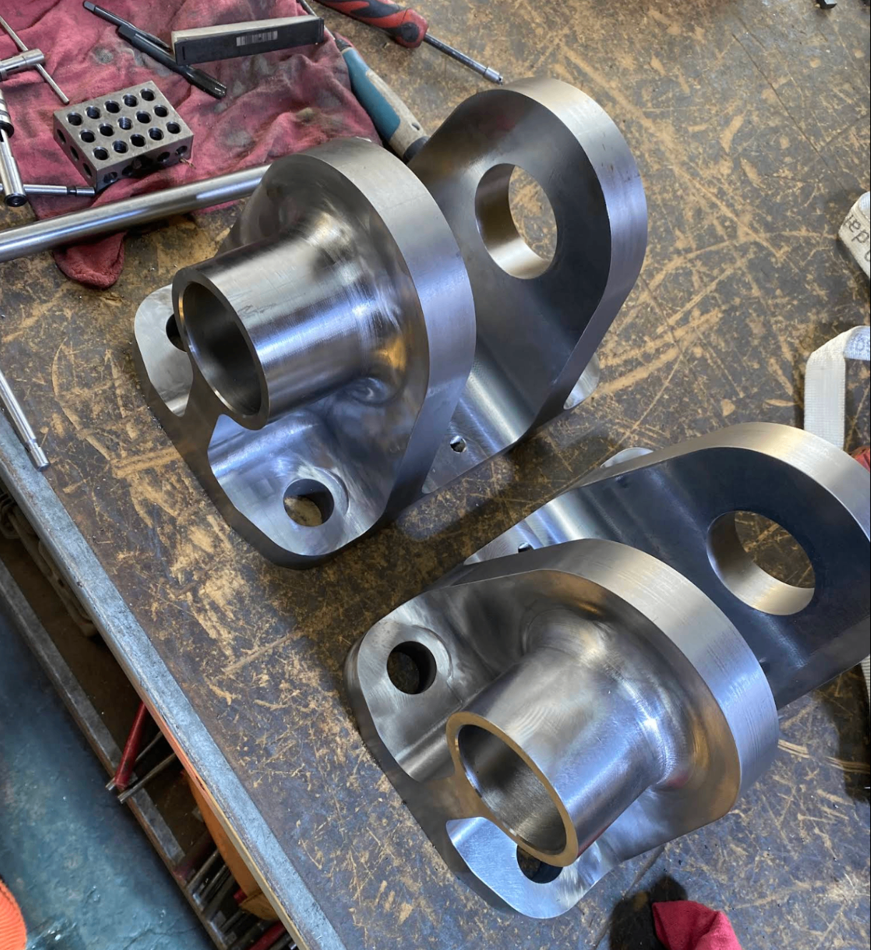 Polished machined steel lifting components on a workbench