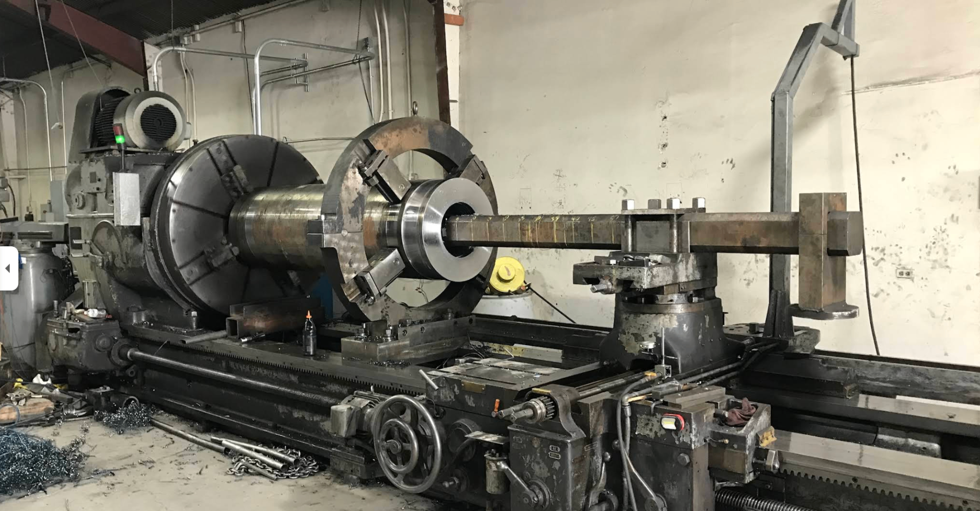 Large industrial lathe machining a heavy steel workpiece